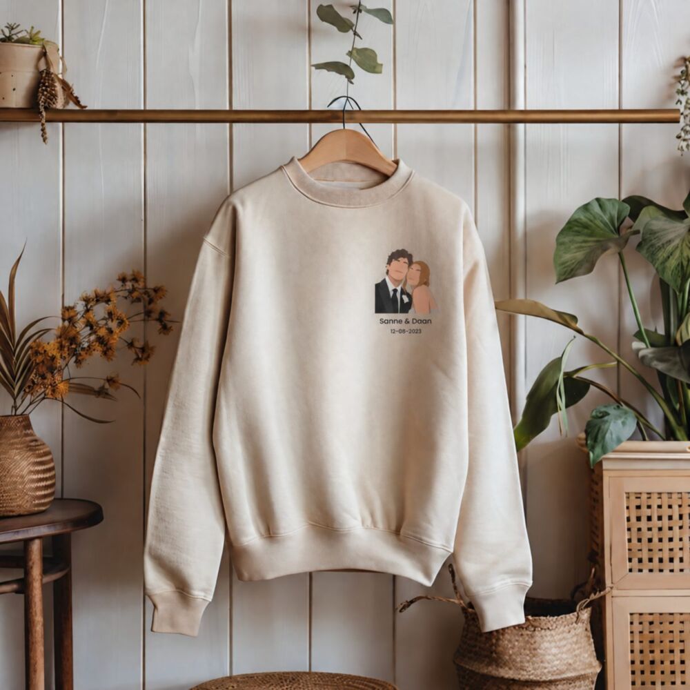 Gepersonaliseerde trui met kleine illustratie in zand op een hanger – koppelillustratie met namen en datum op de borst